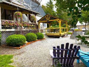 un giardino con due sedie e un gazebo di Lake Ontario Motel & Inn a Newfane