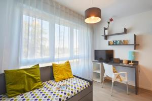 a bedroom with a desk and a bed with yellow pillows at Résidence Nemea, Villeneuve Pont de Bois in Villeneuve d'Ascq