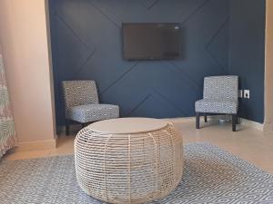 une pièce avec deux chaises, une table et une télévision dans l'établissement Unit 103 Tenbury, à Durban