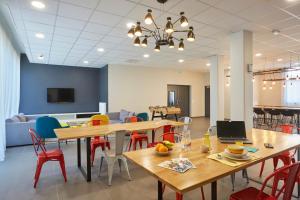a room with tables and chairs and a couch at Résidence Nemea, Villeneuve Pont de Bois in Villeneuve d'Ascq