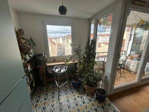 a room with potted plants and a desk and windows at Appartement familial avec balcon et parking in Lyon