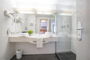 a white bathroom with a sink and a shower at Hotel Residenz in Ravensburg