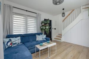 sala de estar con sofá azul y escaleras en Apartment with Garden 450 m to the Beach by Rent like home, en Dziwnówek