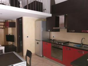 a kitchen with red cabinets and a stainless steel refrigerator at Tiny Beach home in Bisceglie! in Bisceglie