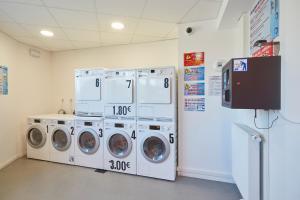 a laundry room with three washing machines and a refrigerator at Résidence Nemea, Villeneuve Pont de Bois in Villeneuve d'Ascq +3 photos