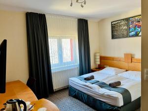 a bedroom with a large bed and a window at Słupsk forest - PREMIUM APARTAMENTS - Kaszubska street 18 - Wifi Netflix Smart TV50 - pleasure quality stay in Słupsk