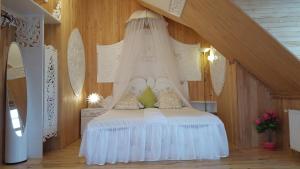 1 dormitorio con 1 cama blanca con dosel en Naiza Guesthouse and Apartments, en Jūrmala