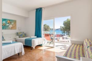1 dormitorio con cama y vistas al océano en Hostal Neptuno en Paguera
