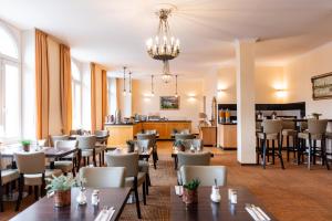 a restaurant with tables and chairs and a bar at Novum Hotel Kronprinz Hamburg Hauptbahnhof in Hamburg