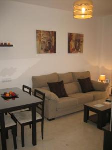 - un salon avec un canapé et une table dans l'établissement APARTAMENTO SEVILLA, à Alcalá de Guadaira
