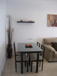 - un salon avec une table et des chaises dans l'établissement APARTAMENTO SEVILLA, à Alcalá de Guadaira