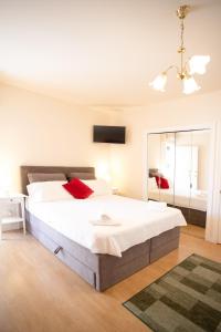 a bedroom with a large white bed and a mirror at Apartments Mijajov Dvor in Sumartin