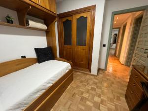 1 dormitorio con 1 cama y suelo de madera en Alojamiento BULEVAR, en Alba de Tormes