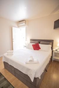 a bedroom with a large white bed with towels on it at Apartments Mijajov Dvor in Sumartin