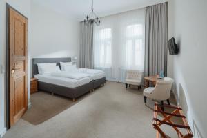 a bedroom with a bed and a desk and a chair at Logierhaus am Denkmal in Norderney