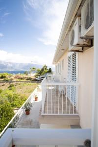 a balcony of a house with a white railing at Apartments Mijajov Dvor in Sumartin