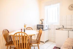cocina con mesa, sillas y microondas en Apartments Mijajov Dvor en Sumartin