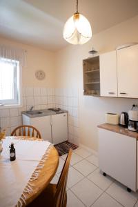 cocina con mesa y cocina con armarios blancos en Apartments Mijajov Dvor en Sumartin