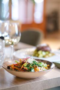 een kom salade op een tafel met een glas wijn bij Can Xim-Turismo de Interior in Alaró