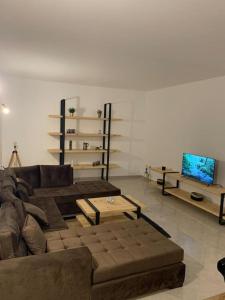 a living room with a couch and a tv at Dar Midoun Villa with pool in center city in Midoun