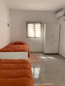 Dieses weiße Zimmer verfügt über 2 Betten und einen Kühlschrank. in der Unterkunft Dar Midoun Villa with pool in center city in Midoun