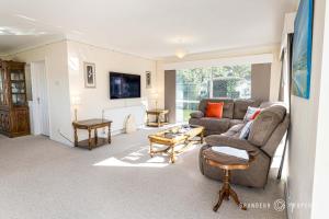 sala de estar con sofá y mesa en Large bungalow with garden, sleeps 6, Wi-Fi & parking - Heathside Retreat en West Parley