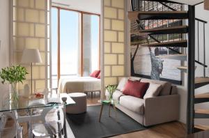 a living room with a couch and a spiral staircase at Eric Vökel Boutique Apartments - Riverfront Suites in Amsterdam