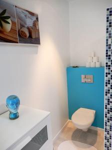 a bathroom with a toilet and a blue cabinet at L'Ecume De Jade in La Plaine-sur-Mer