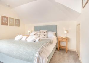 a bedroom with a large bed with white sheets at Barnaby Lodge in Aldeburgh