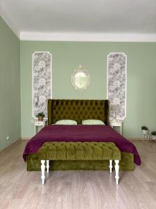 リヴィウにあるEdem Apartments in Lvivのベッドルーム1室(紫色のベッドカバー付きの大型ベッド1台付)