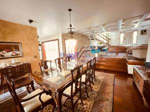a dining room with a long table and chairs at Casa Flora Garden & Pool in Carapicuíba