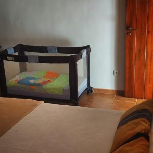 Una cuna en un dormitorio con cama en La Caseta de Rotova - Casa Rural para desconectar, en Ròtova