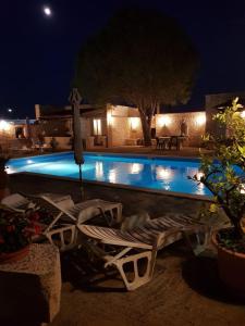 - une piscine avec des chaises et un parasol la nuit dans l'établissement Ferienwohnung für 4 Personen in Buici, Istrien, à Buici
