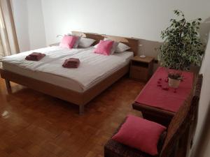 Un dormitorio con una cama con almohadas rosas y una mesa. en Ferienwohnung für 4 Personen in Buici, Istrien, en Buici