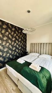 a bedroom with a large bed with a green blanket at Baltic Gdansk OLD TOWN in Gdańsk