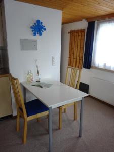 - une table et des chaises blanches dans une chambre avec fenêtre dans l'établissement Ferienwohnung Inauen, à Appenzell