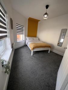 een slaapkamer met een bed en 2 ramen bij 50 Wood St in Burton upon Trent