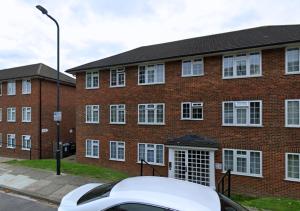 a white car parked in front of a brick building at FW Haute Apartments at Wembley, Ground Floor 2 Bedroom and 1 Bathroom Flat, King or Twin beds and Double bed with FREE WIFI and FREE PARKING in London