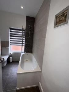 a white bath tub in a bathroom with a sink at 50 Wood St in Burton upon Trent