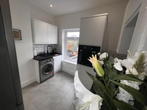 een keuken met een wasmachine en een raam bij 50 Wood St in Burton upon Trent