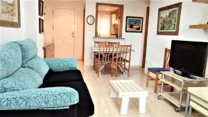uma sala de estar com um sofá azul e uma mesa em ACV- Costa Marina I-1ªlinea planta 5 norte em Oropesa del Mar