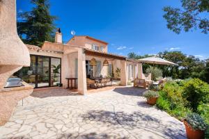 een extern uitzicht op een huis met een patio bij Villa Silia in the Gulf of Saint-Tropez in a natural setting in La Garde-Freinet