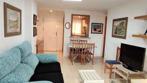 uma sala de estar com um sofá azul e uma mesa em ACV- Costa Marina I-1ªlinea planta 5 norte em Oropesa del Mar