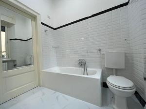 baño blanco con bañera y aseo en BG Central President Suite con parcheggio - Vista Città Alta, en Bérgamo