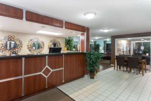 a restaurant with a bar and a dining room at Days Inn by Wyndham Port Charlotte Town Center in Port Charlotte