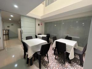 two tables and chairs in a restaurant with white table cloth at Vianca Hotel in Machu Picchu