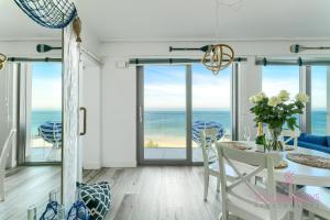 a dining room with a table and views of the ocean at Your Holidays Promenada Gwiazd 14 in Międzyzdroje