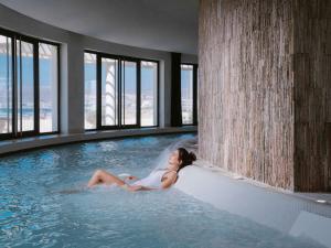 فندق سوفيتيل أغادير بحر وسبا ثالاسا في أغادير: وجود امرأة جالسة في مسبح في مبنى
