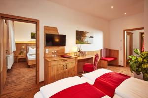 a bedroom with a bed and a desk with a television at Donauhotel Lettnerhof in Au an der Donau