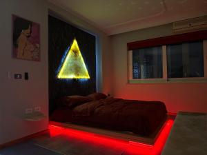 - une chambre dotée d'un lit avec une lumière rouge dans l'établissement ONUS Premium Suite CityCenter, à Tirana